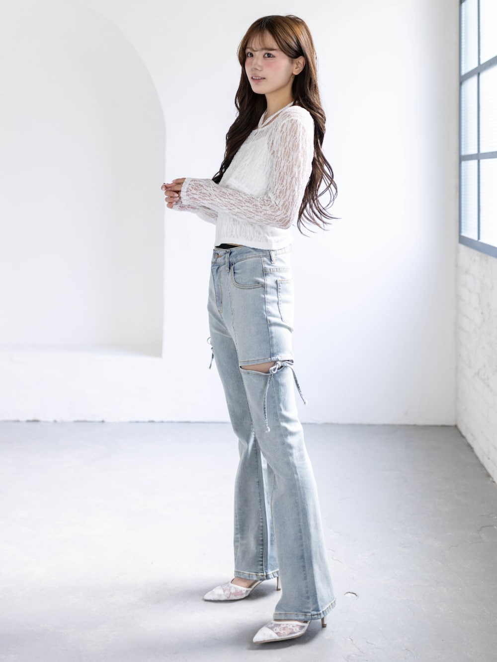 ホワイト系のパンプス、ホワイト系のカーディガン/ボレロ、ブルー系のデニムパンツを着用したレディースの春コーディネートの2枚目の写真