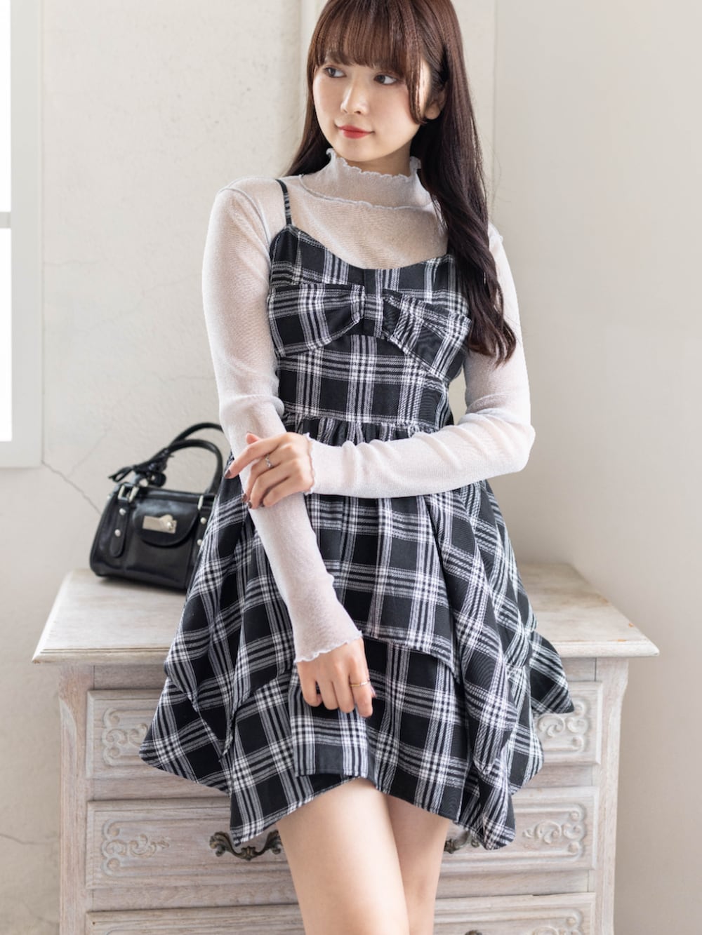 グレー系のTシャツ/カットソー、ブラック系のワンピース、ブラック系のブーツを着用したレディースの春コーディネートの5枚目の写真