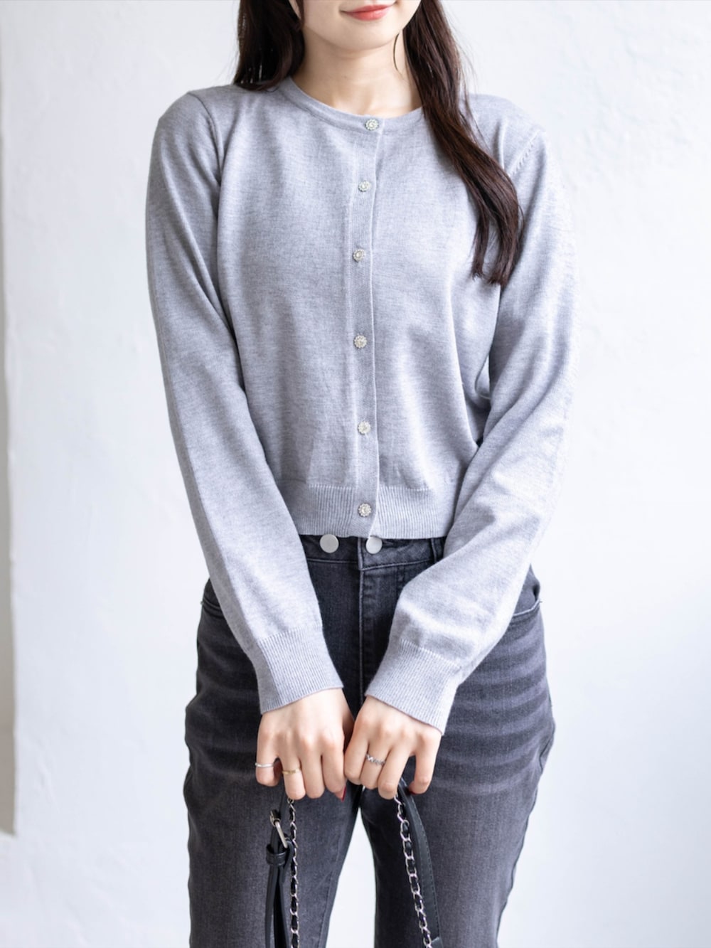 ブラック系のデニムパンツ、ブラック系のパンプス、グレー系のニット/セーターを着用したレディースの秋コーディネートの5枚目の写真