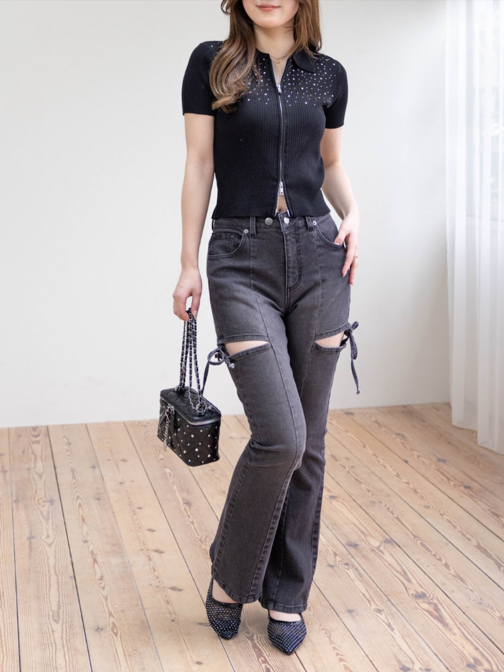 ブラック系のパンプス、ブラック系のデニムパンツ、ブラック系のニット/セーターを着用したレディースの春コーディネートの2枚目の写真