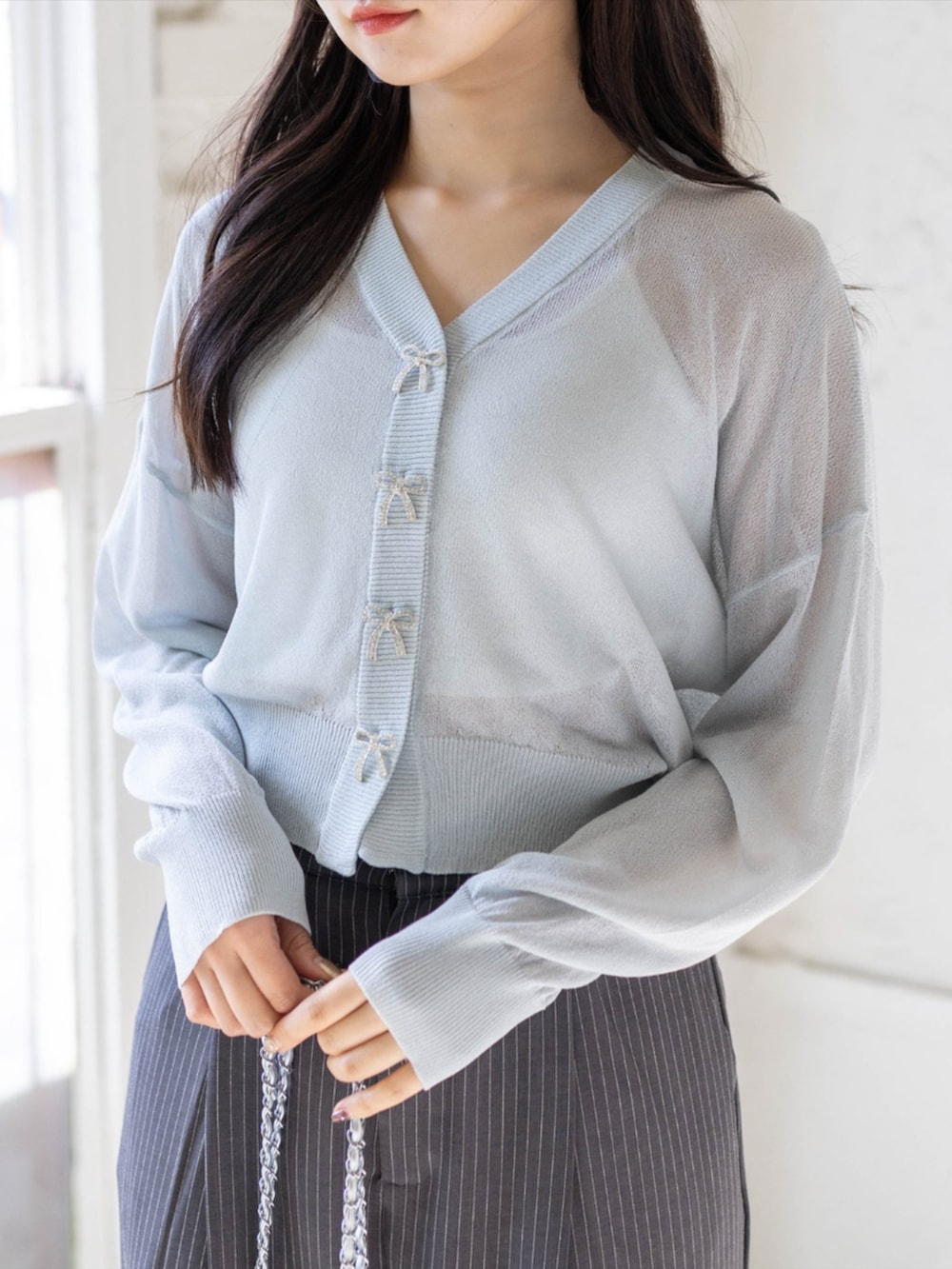 シルバー系のパンプス、グレー系のスラックス、グレー系のカーディガン/ボレロを着用したレディースの春コーディネートの4枚目の写真