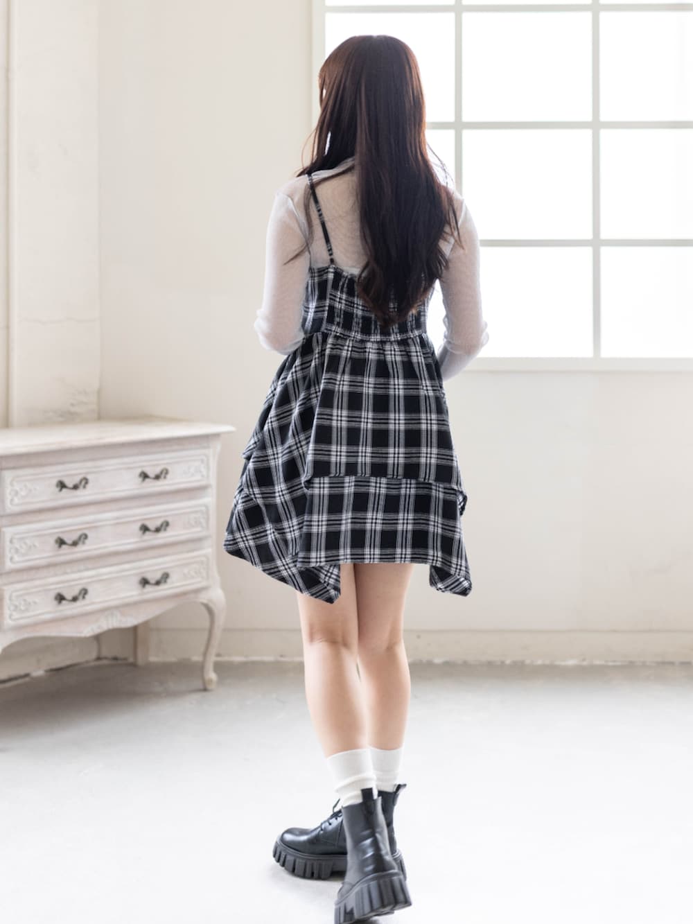 グレー系のTシャツ/カットソー、ブラック系のワンピース、ブラック系のブーツを着用したレディースの春コーディネートの3枚目の写真