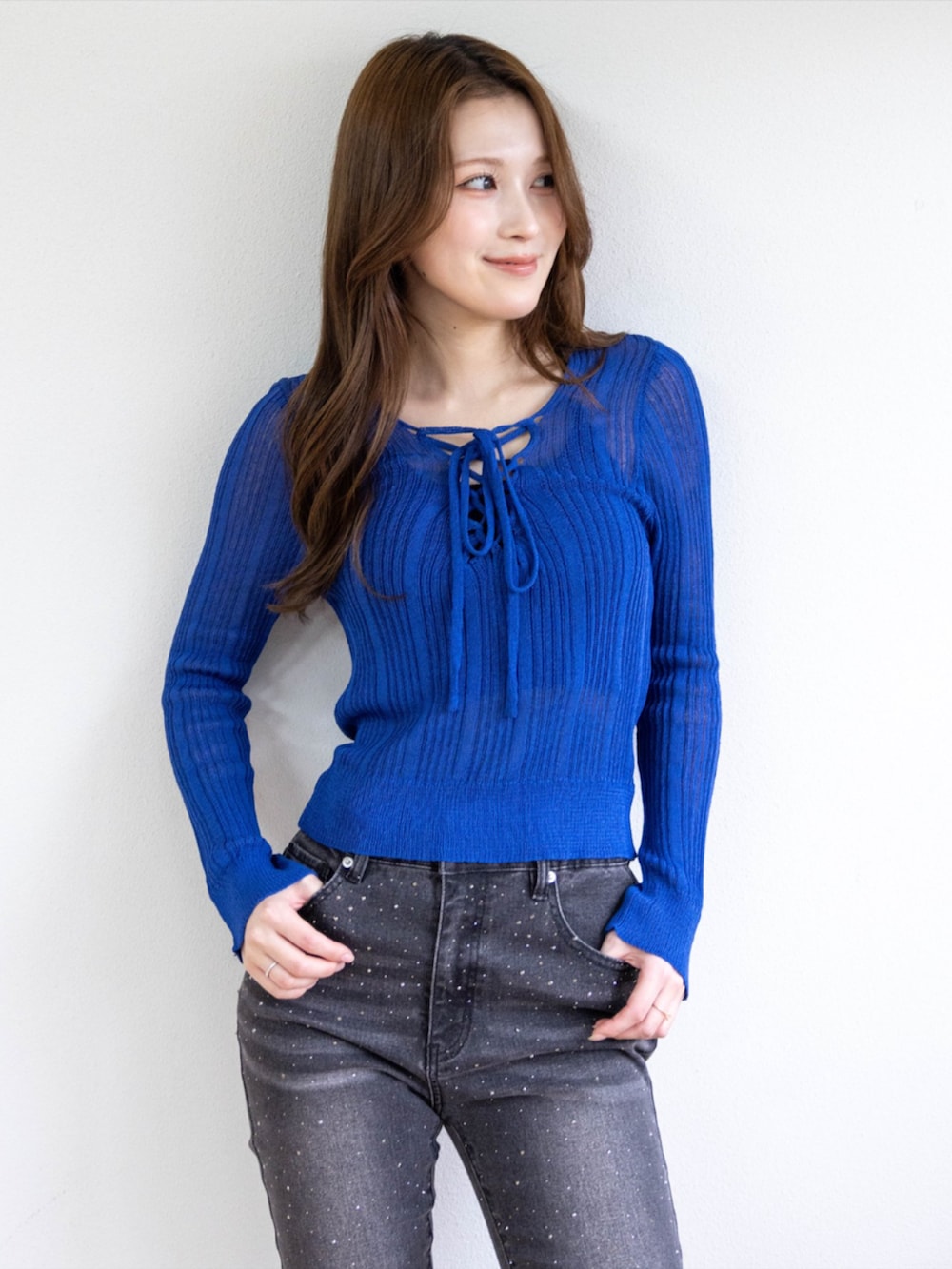 シルバー系のパンプス、ブラック系のデニムパンツ、ブルー系のニット/セーターを着用したレディースの春コーディネートの4枚目の写真