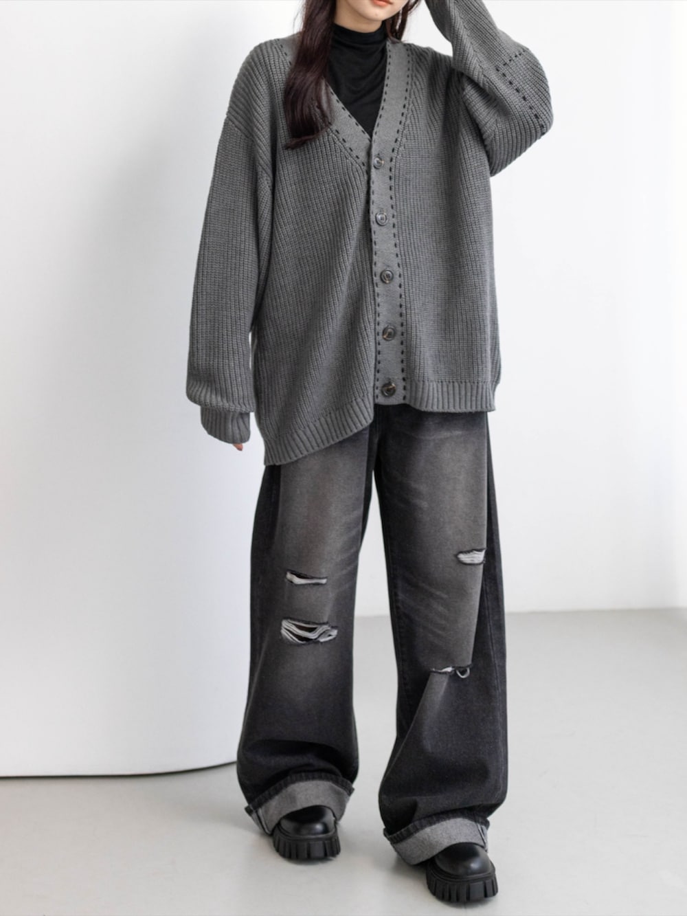 ブラック系のTシャツ/カットソー、ブラック系のデニムパンツ、ブラック系のブーツを着用したレディースの秋コーディネートの6枚目の写真