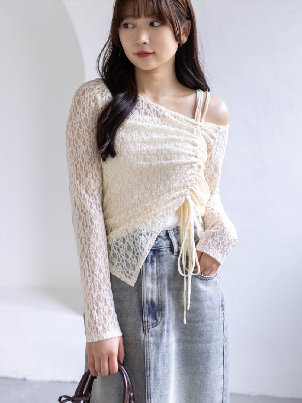 ブラウン系のボストンバッグ、ホワイト系のスニーカー、ブルー系のスカートを着用したレディースの春コーディネートの4枚目の写真