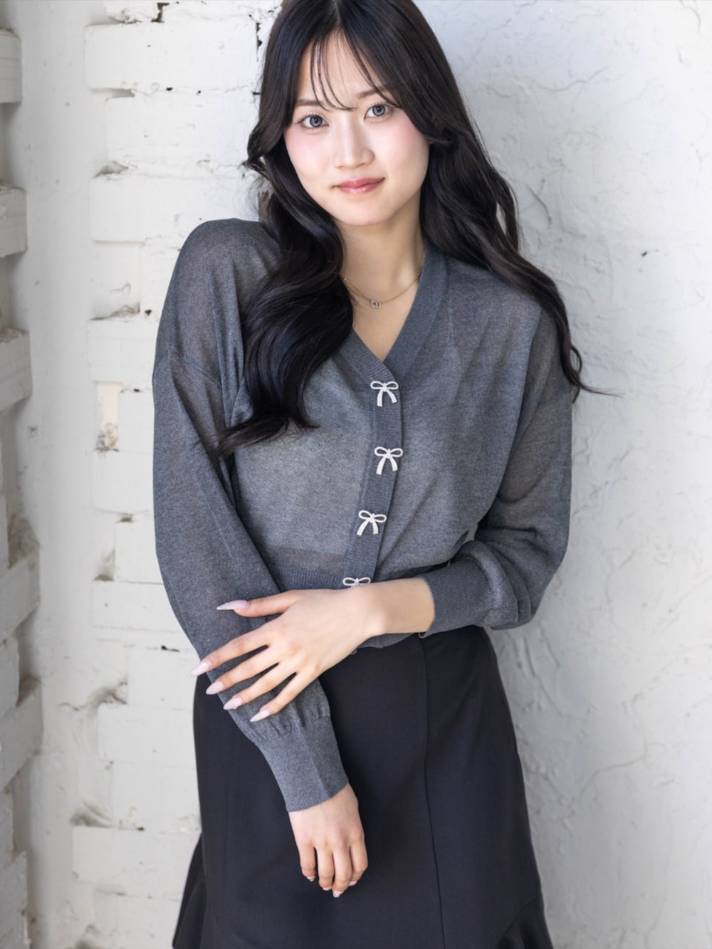 ブラック系のパンプス、ブラック系のスカート、グレー系のカーディガン/ボレロを着用したレディースの春コーディネートの4枚目の写真