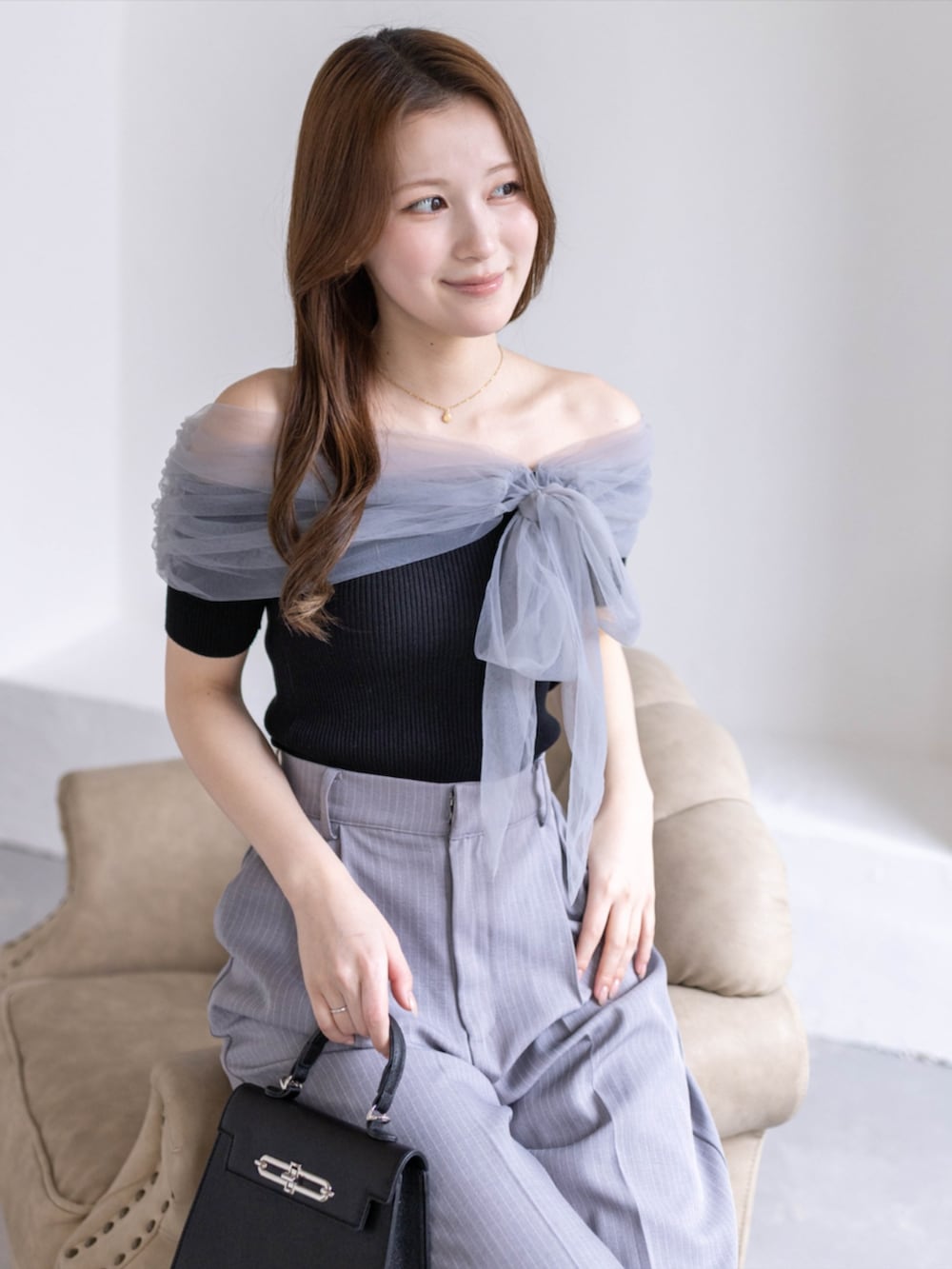 ブラック系のパンプス、ブラック系のニット/セーター、グレー系のスラックスを着用したレディースの春コーディネートの4枚目の写真