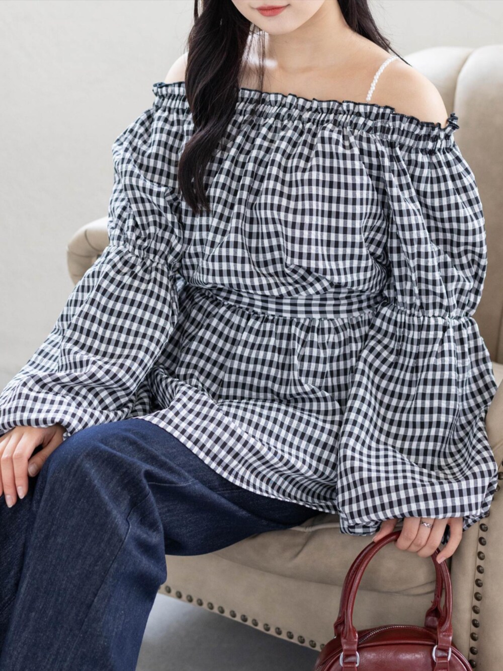 レッド系のパンプス、ブルー系のデニムパンツ、ブラック系のチュニックを着用したレディースの夏コーディネートの3枚目の写真