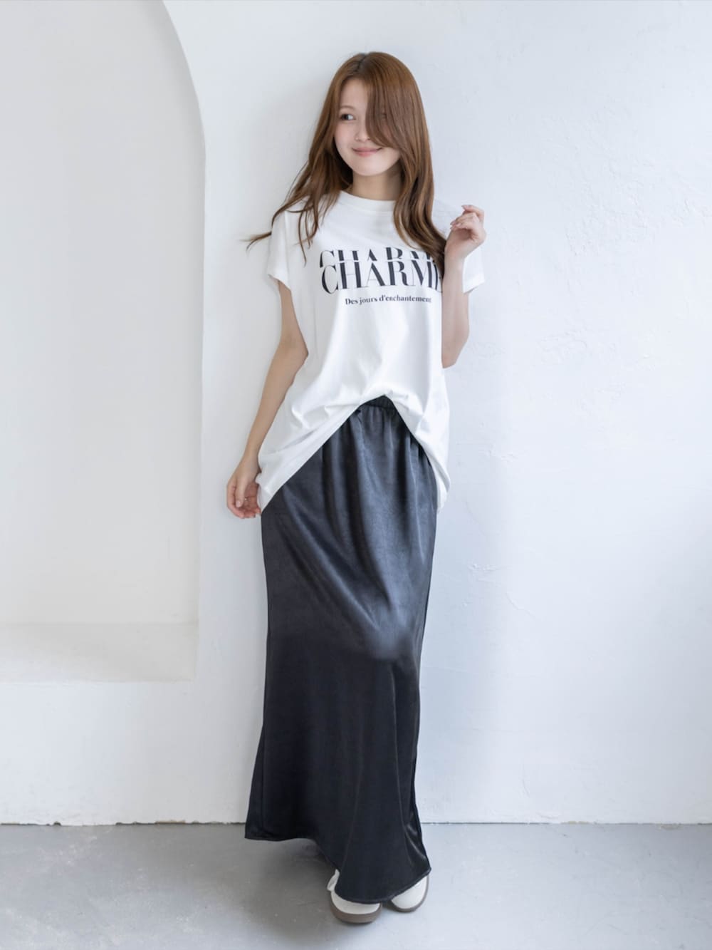 ホワイト系のスニーカー、ブラック系のスカート、ホワイト系のTシャツ/カットソーを着用したレディースの春コーディネートの3枚目の写真