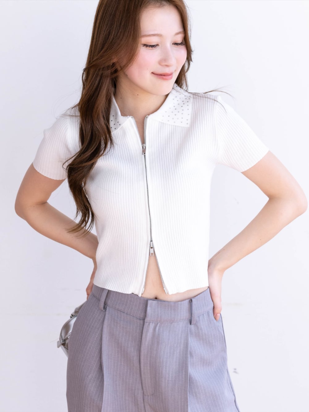 グレー系のスラックス、ホワイト系のパンプス、ホワイト系のニット/セーターを着用したレディースの春コーディネートの4枚目の写真