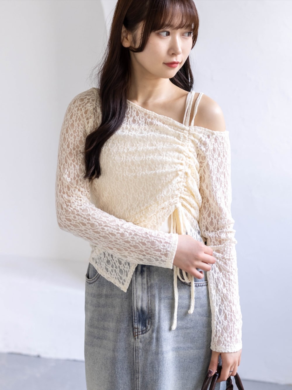 ブラウン系のボストンバッグ、ホワイト系のスニーカー、ブルー系のスカートを着用したレディースの春コーディネートの3枚目の写真