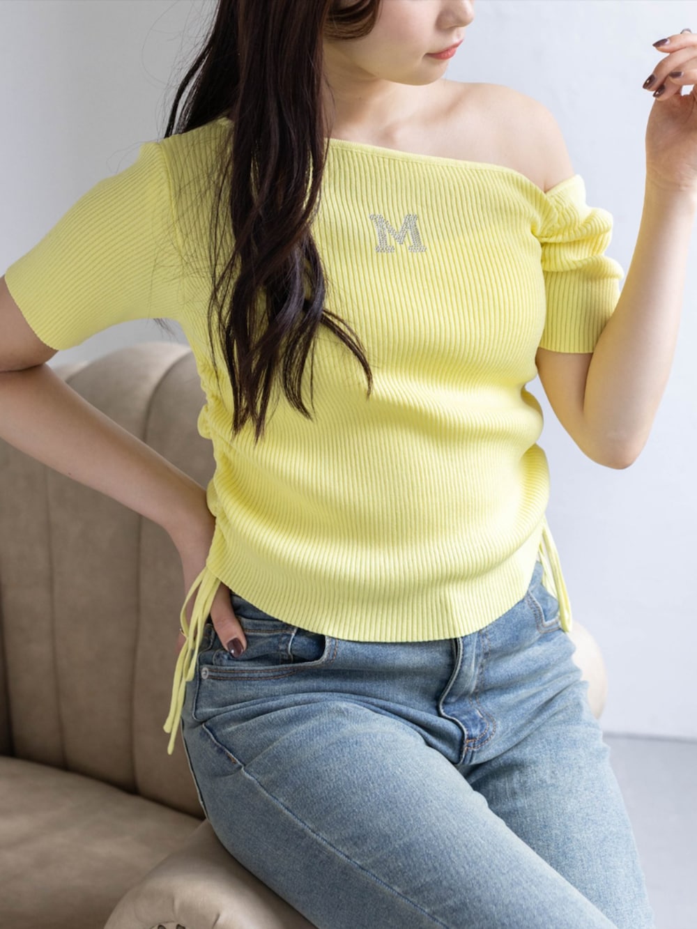 ホワイト系のスニーカー、ブルー系のデニムパンツ、イエロー系のニット/セーターを着用したレディースの春コーディネートの3枚目の写真