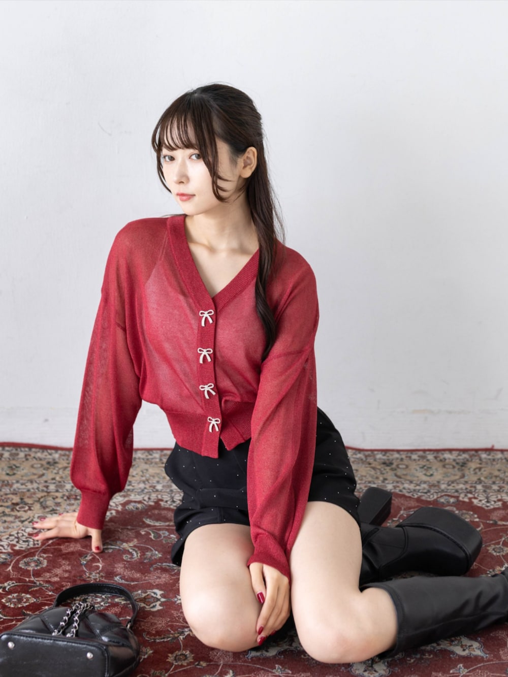 ブラック系のその他パンツ、ブラック系のブーツ、レッド系のカーディガン/ボレロを着用したレディースの秋コーディネートの6枚目の写真