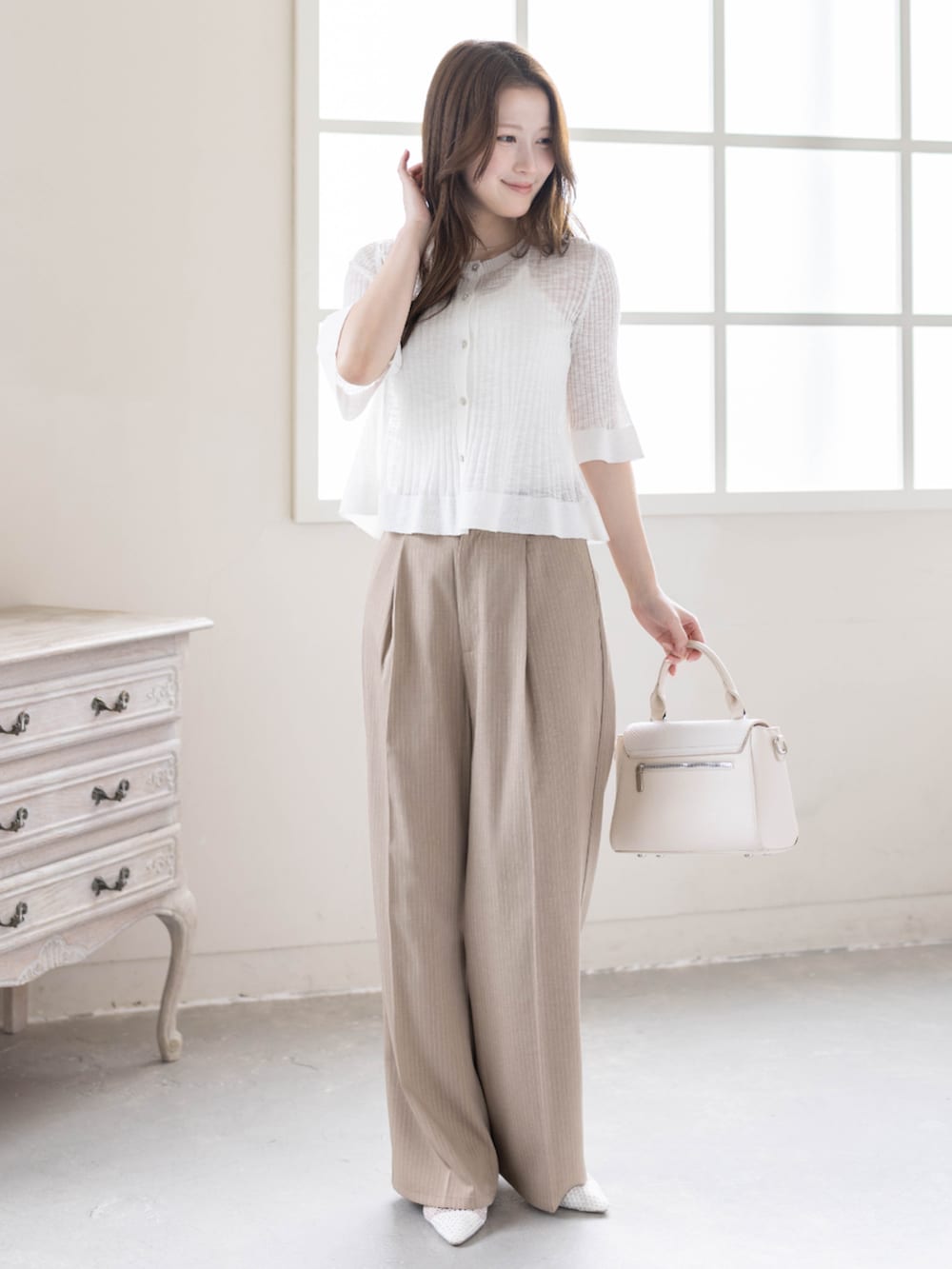 ベージュ系のスラックス、ホワイト系のパンプス、ホワイト系のカーディガン/ボレロを着用したレディースの春コーディネートの4枚目の写真