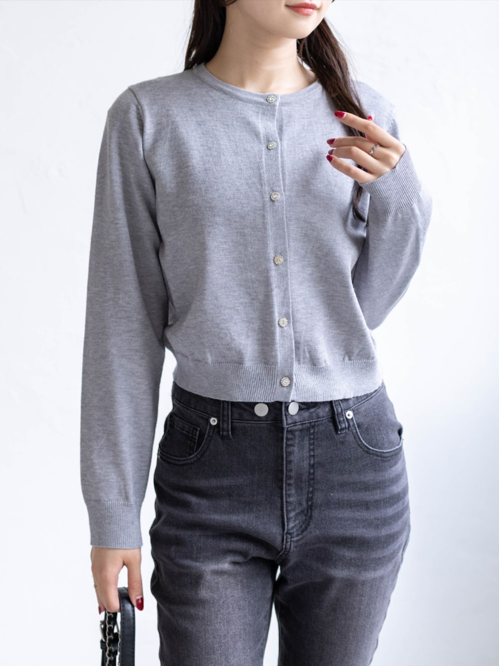 ブラック系のデニムパンツ、ブラック系のパンプス、グレー系のニット/セーターを着用したレディースの秋コーディネートの4枚目の写真