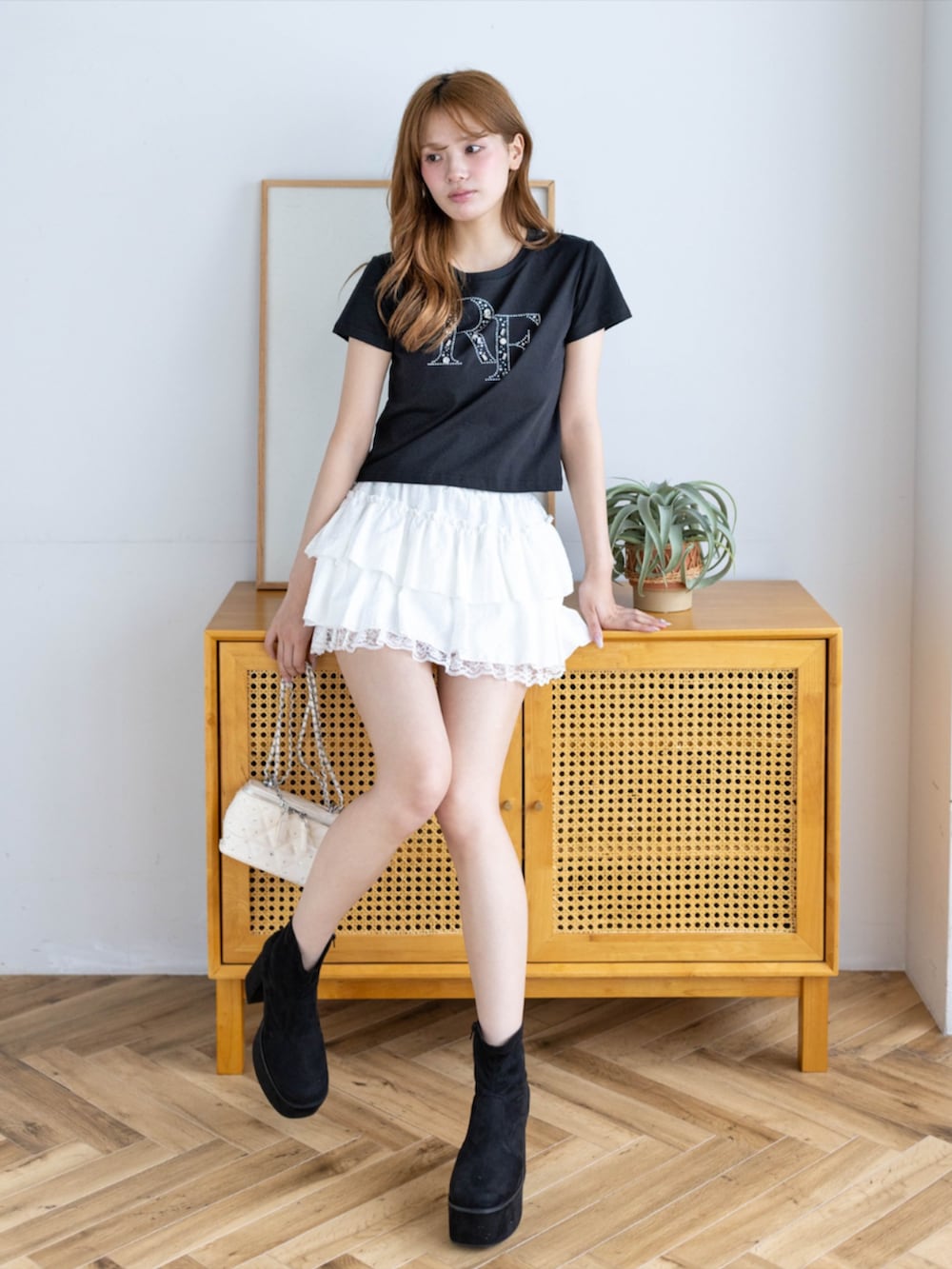 ホワイト系のスカート、ブラック系のTシャツ/カットソーを着用したレディースの夏コーディネートの2枚目の写真