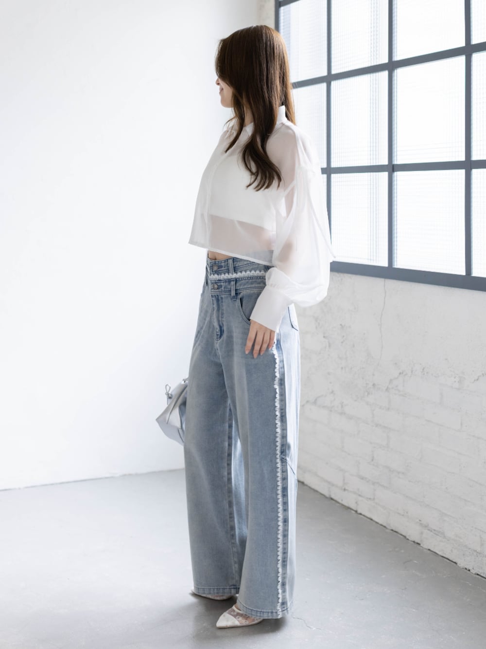 ブルー系のデニムパンツ、ホワイト系のパンプス、ホワイト系のシャツ/ブラウスを着用したレディースの春コーディネートの2枚目の写真