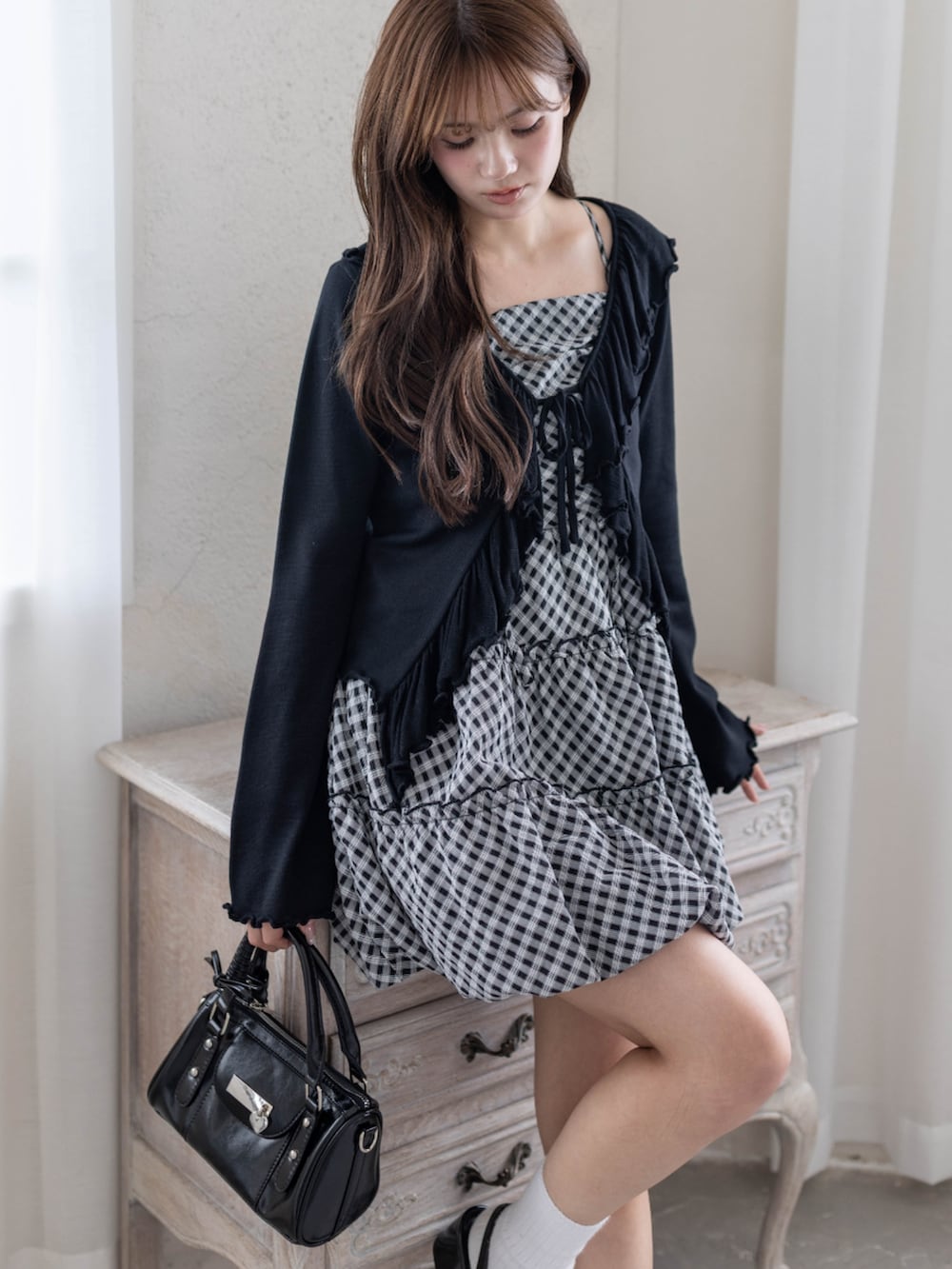 ブラック系のパンプス、ブラック系のハンドバッグ、ブラック系のワンピースを着用したレディースの春コーディネートの3枚目の写真