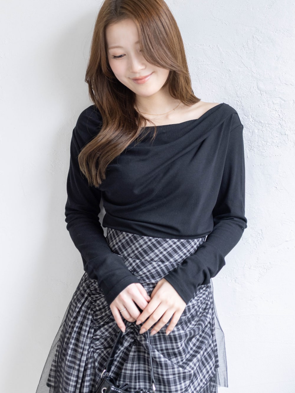 ブラック系のハンドバッグ、ブラック系のTシャツ/カットソー、ブラック系のスカートを着用したレディースの春コーディネートの5枚目の写真