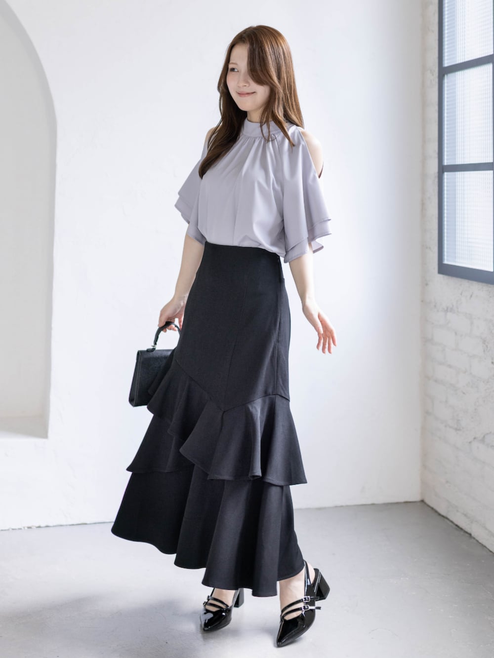 ブラック系のパンプス、グレー系のシャツ/ブラウス、ブラック系のハンドバッグを着用したレディースの春コーディネートの3枚目の写真