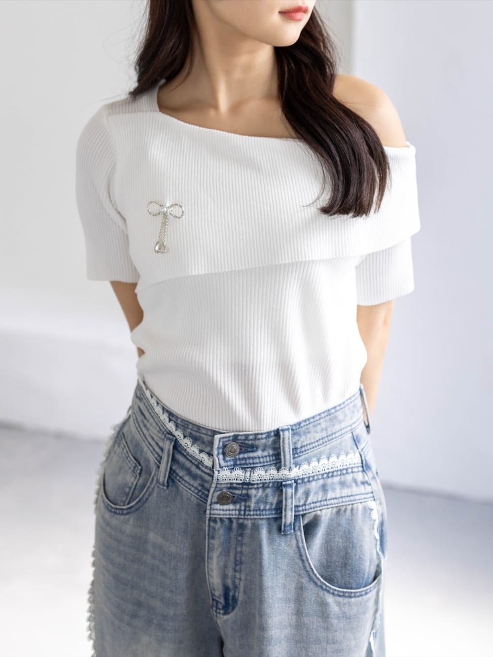 ブルー系のデニムパンツ、ホワイト系のパンプス、ホワイト系のニット/セーターを着用したレディースの春コーディネートの5枚目の写真