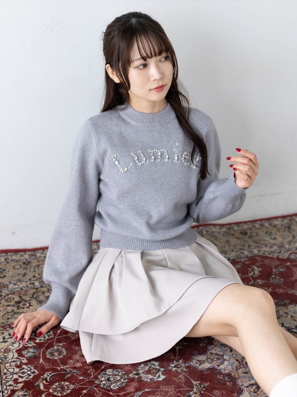 ブラック系のローファー、グレー系のニット/セーター、ベージュ系のスカートを着用したレディースの秋コーディネートの8枚目の写真