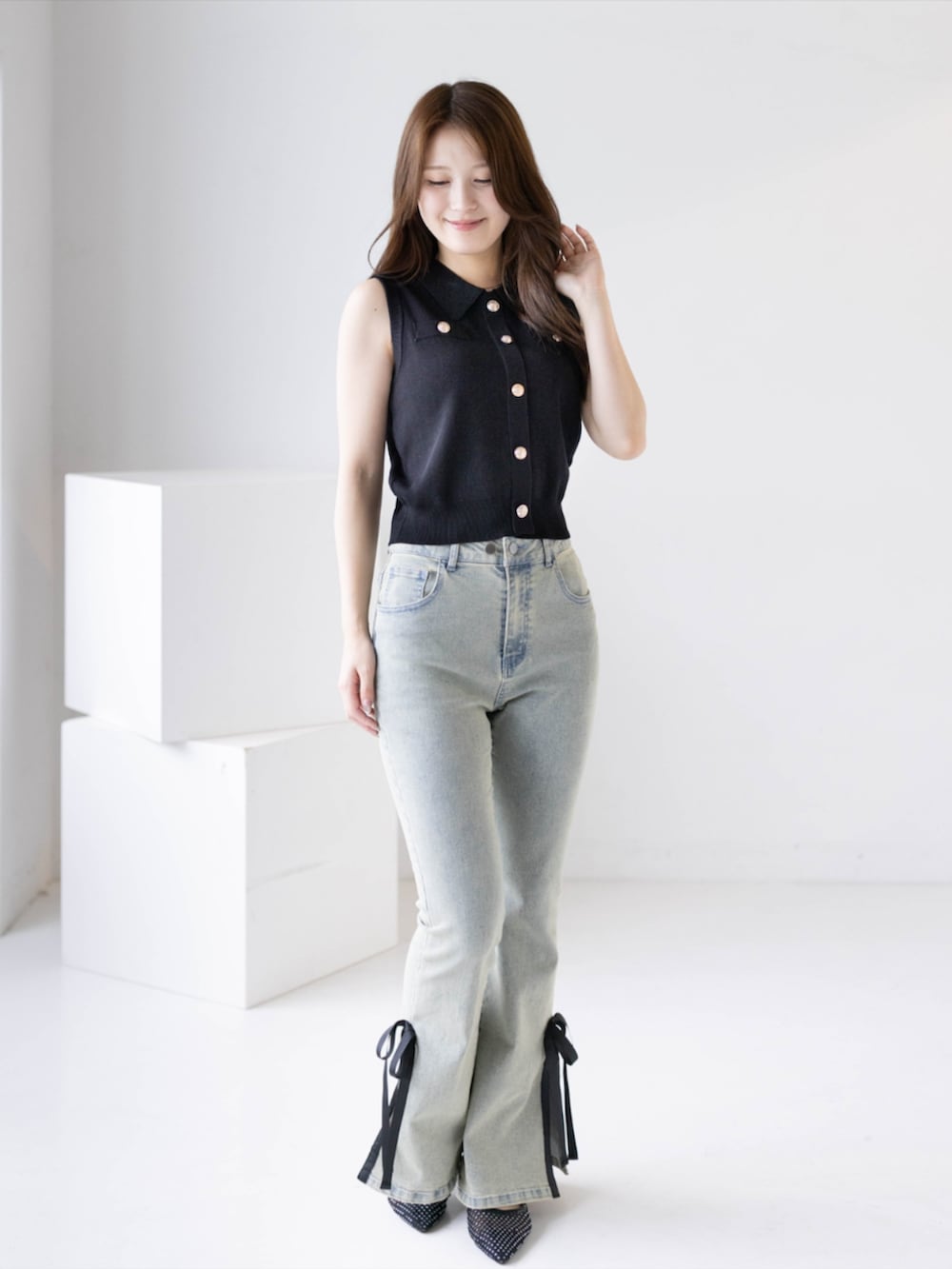 ブラック系のパンプス、ブルー系のデニムパンツ、ブラック系のニット/セーターを着用したレディースの夏コーディネートの2枚目の写真