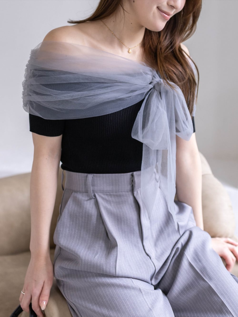 ブラック系のパンプス、ブラック系のニット/セーター、グレー系のスラックスを着用したレディースの春コーディネートの5枚目の写真