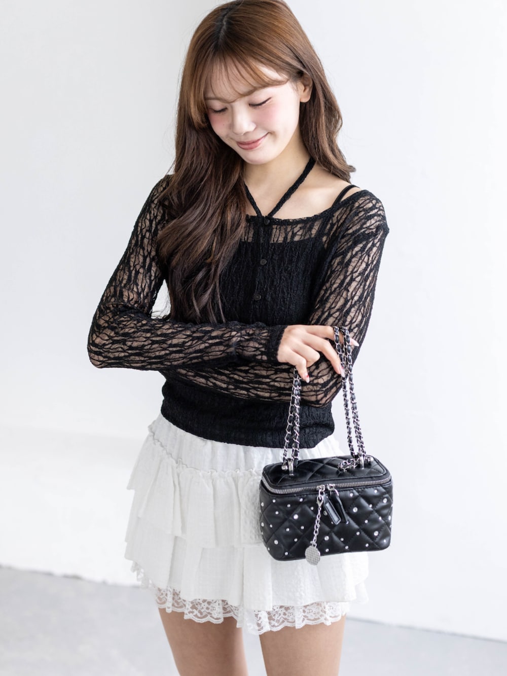 ブラック系のパンプス、ブラック系のショルダーバッグ、ブラック系のカーディガン/ボレロを着用したレディースの春コーディネートの6枚目の写真