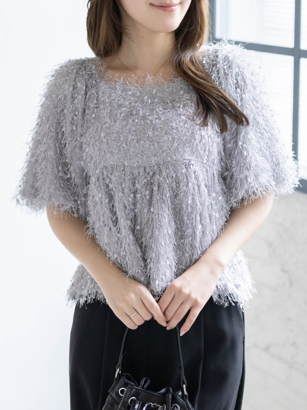 ブラック系のハンドバッグ、ブラック系のパンプス、グレー系のシャツ/ブラウスを着用したレディースの春コーディネートの5枚目の写真