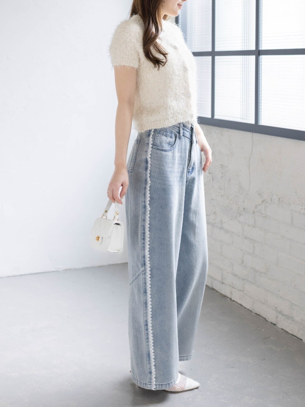 ホワイト系のパンプス、ホワイト系のカーディガン/ボレロ、ブルー系のデニムパンツを着用したレディースの春コーディネートの4枚目の写真