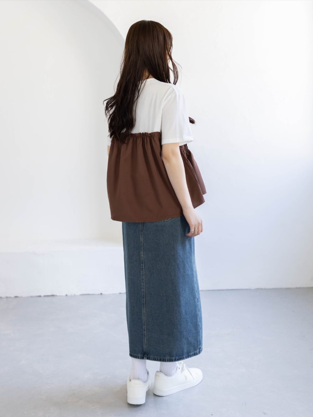 ブルー系のデニムスカート、ゴールド系のスニーカー、ブラウン系のTシャツ/カットソーを着用したレディースの夏コーディネートの3枚目の写真