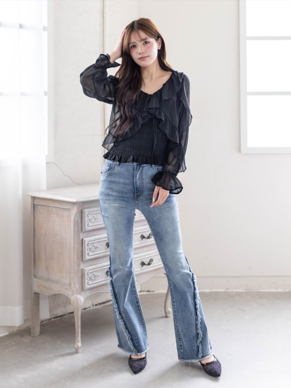 ブルー系のデニムパンツ、ブラック系のパンプス、ブラック系のシャツ/ブラウスを着用したレディースの春コーディネートの2枚目の写真