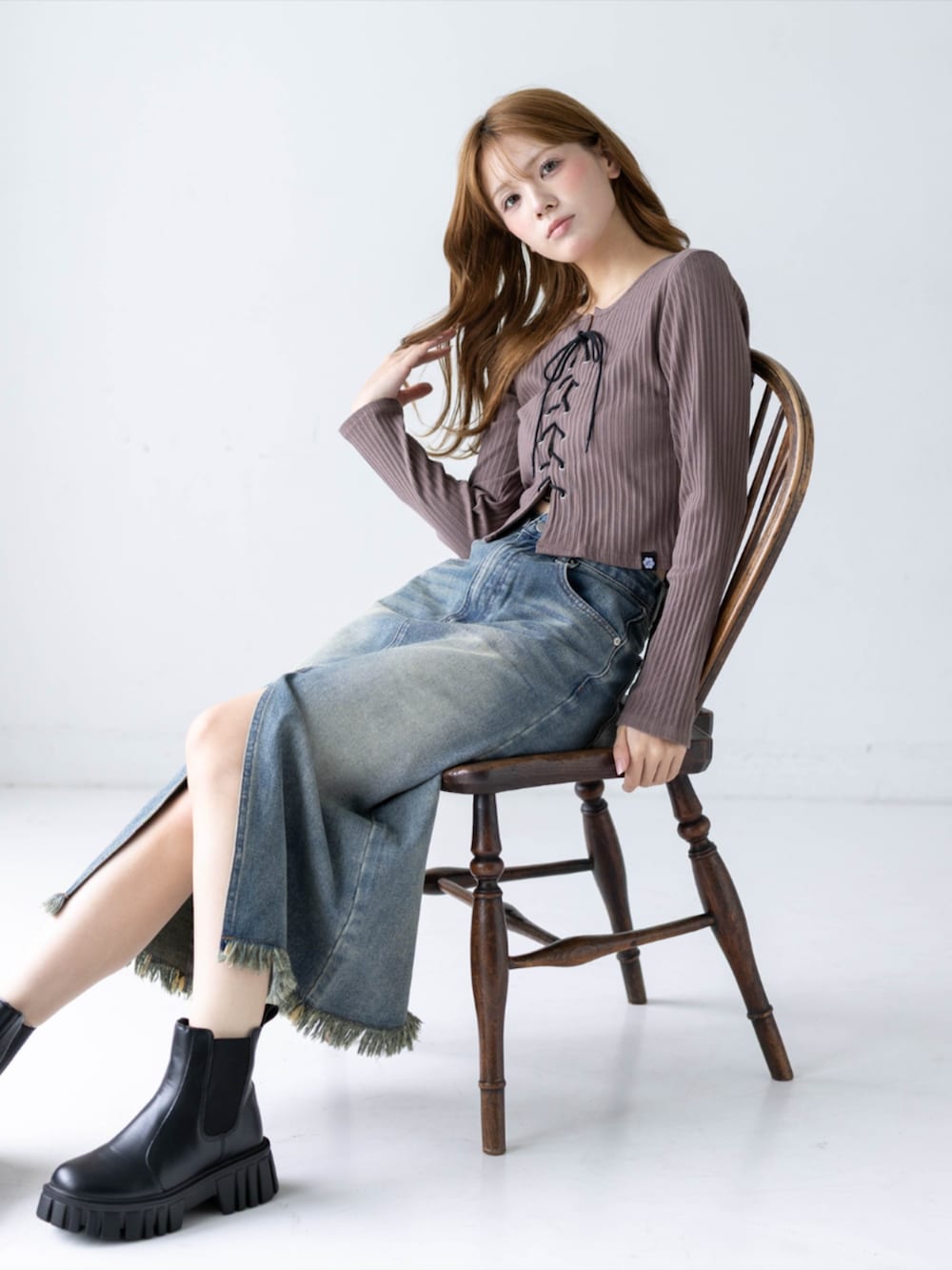 ブルー系のデニムスカート、ブラウン系のTシャツ/カットソー、ブラック系のブーツを着用したレディースの秋コーディネートの6枚目の写真