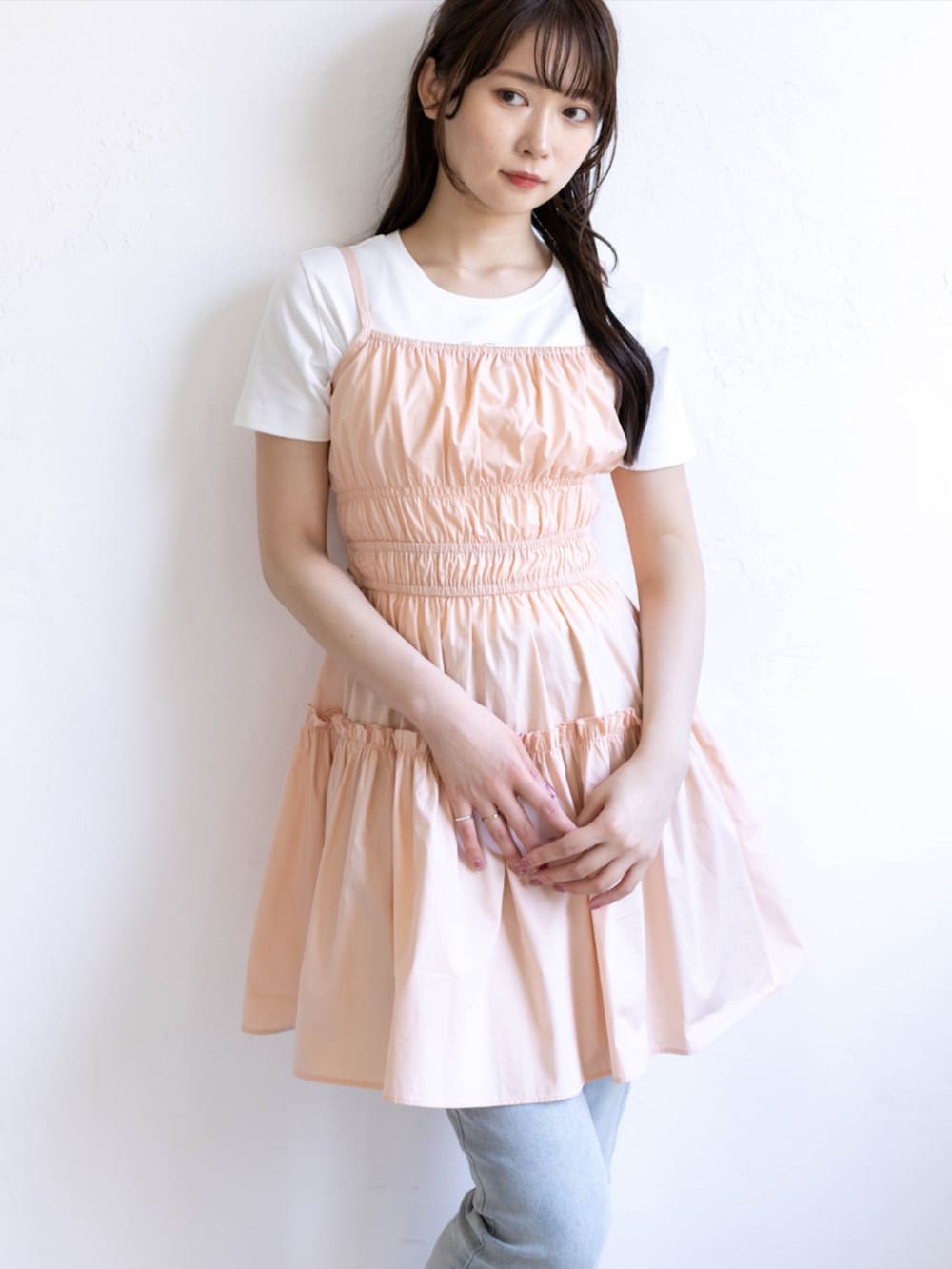 ブルー系のデニムパンツ、ホワイト系のサンダル、ピンク系のワンピースを着用したレディースの夏コーディネートの7枚目の写真