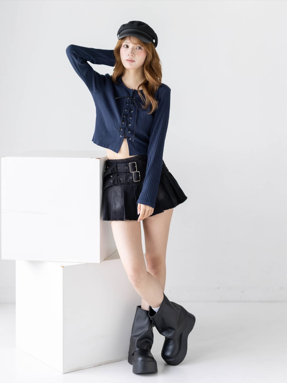 ブラック系のスカート、ブラック系のブーツ、ブルー系のTシャツ/カットソーを着用したレディースの秋コーディネートの2枚目の写真
