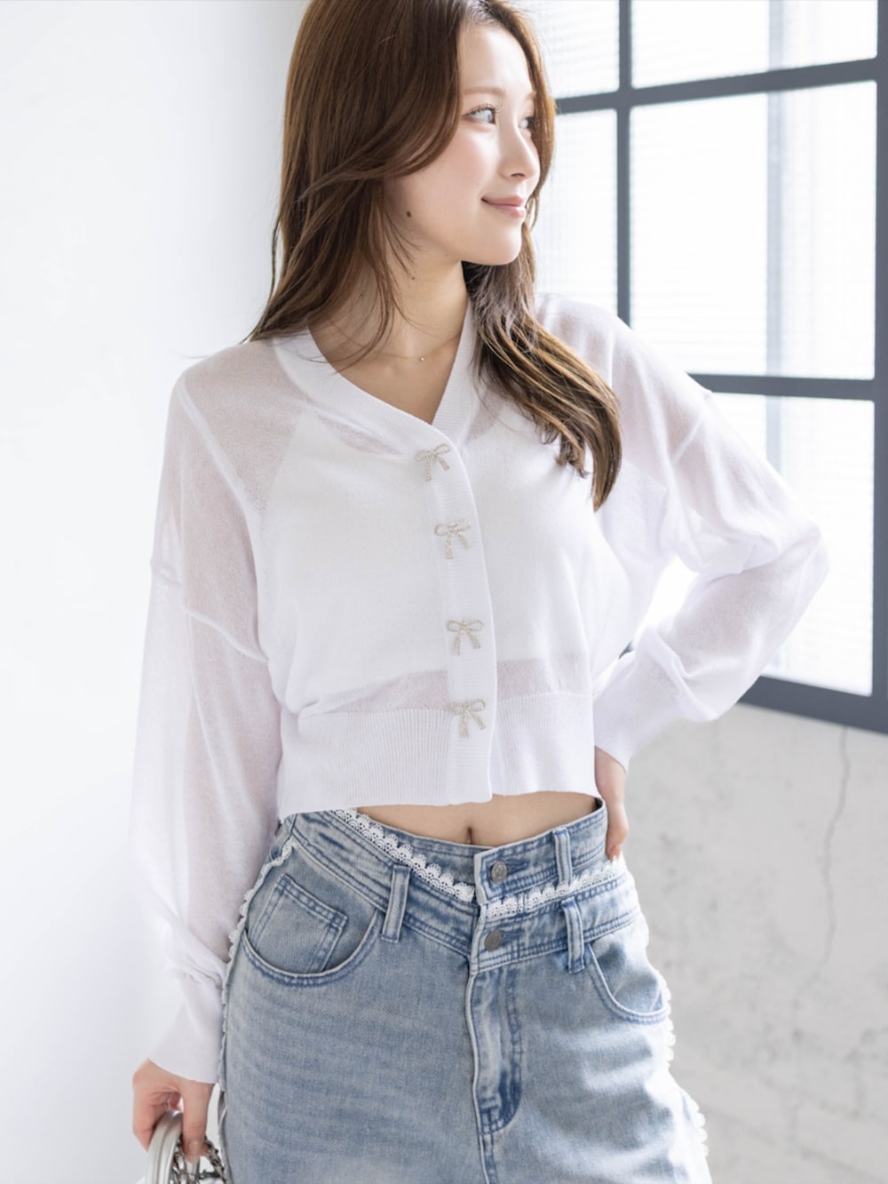 ブルー系のデニムパンツ、ホワイト系のパンプス、ホワイト系のカーディガン/ボレロを着用したレディースの春コーディネートの4枚目の写真