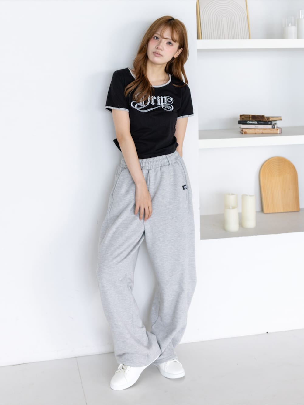 ゴールド系のスニーカー、グレー系のスウェットパンツ、ブラック系のTシャツ/カットソーを着用したレディースの夏コーディネートの2枚目の写真