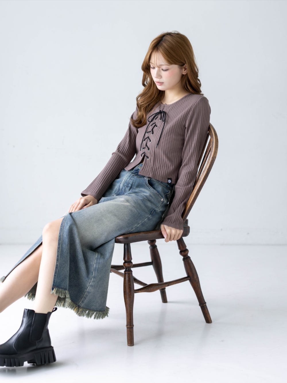 ブルー系のデニムスカート、ブラウン系のTシャツ/カットソー、ブラック系のブーツを着用したレディースの秋コーディネートの5枚目の写真