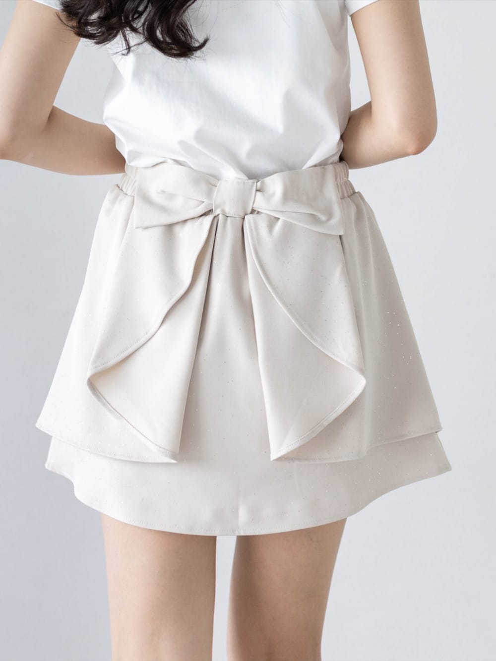 シルバー系のパンプス、ホワイト系のTシャツ/カットソー、ホワイト系のスカートを着用したレディースの夏コーディネートの5枚目の写真