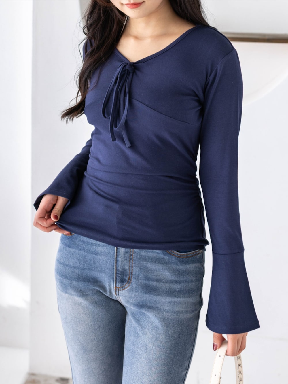 ブルー系のデニムパンツ、ホワイト系のパンプス、ブルー系のTシャツ/カットソーを着用したレディースの夏コーディネートの3枚目の写真
