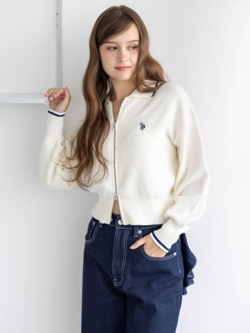 ゴールド系のスニーカー、ブルー系のデニムパンツ、ホワイト系のTシャツ/カットソーを着用したレディースの秋コーディネートの5枚目の写真