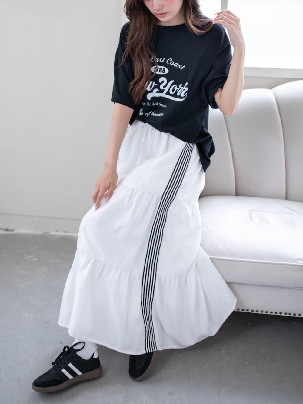 ブラック系のスニーカー、ホワイト系のスカート、ブラック系のTシャツ/カットソーを着用したレディースの夏コーディネートの5枚目の写真