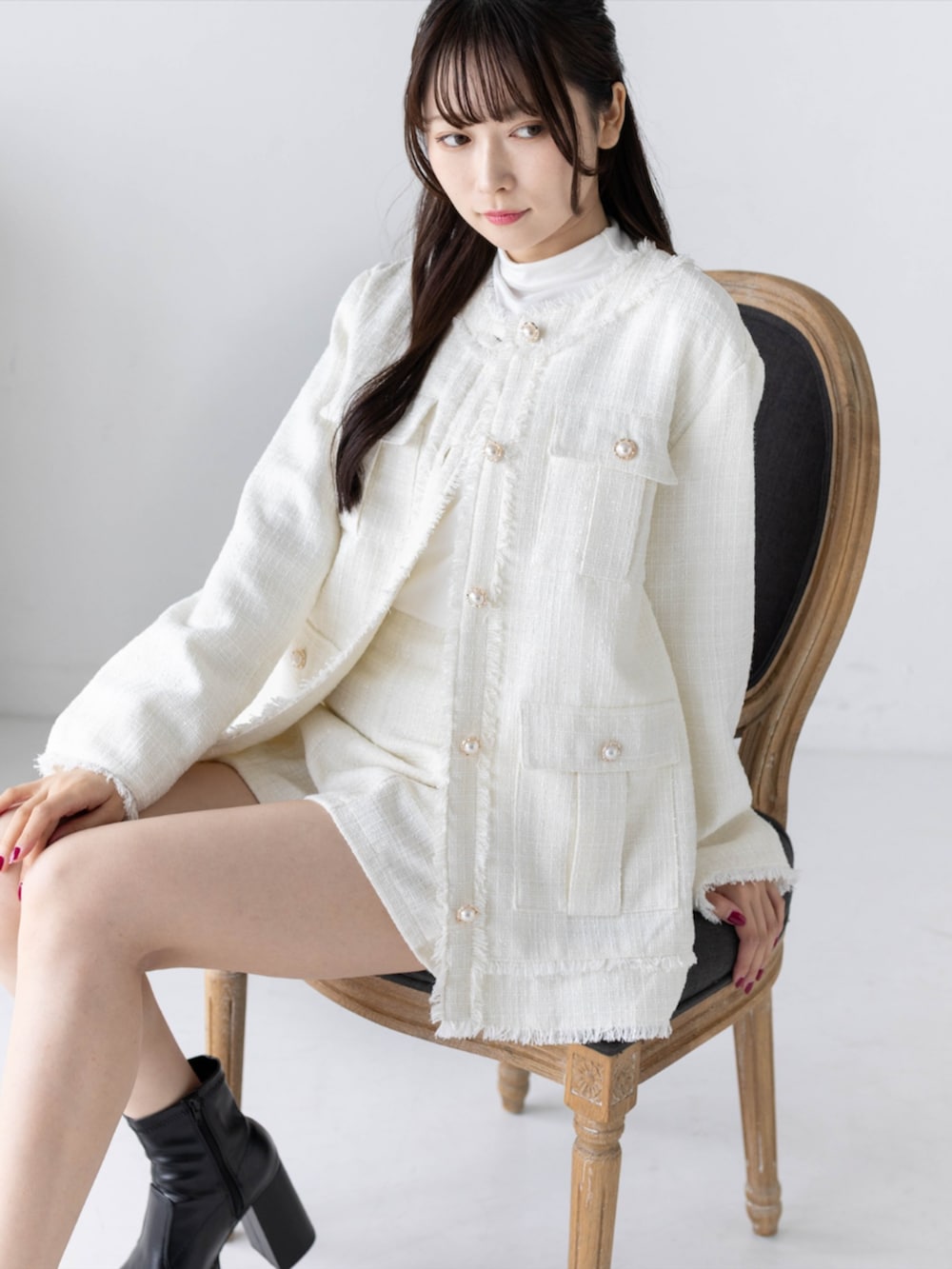 ホワイト系のTシャツ/カットソー、ブラック系のブーツ、ホワイト系のノーカラージャケットを着用したレディースの秋コーディネートの5枚目の写真