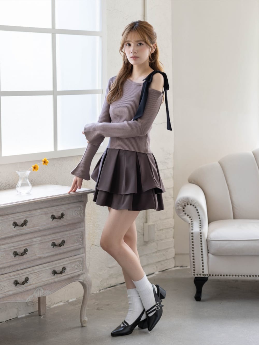 ブラウン系のスカート、ブラック系のパンプス、ブラウン系のニット/セーターを着用したレディースの秋コーディネートの3枚目の写真