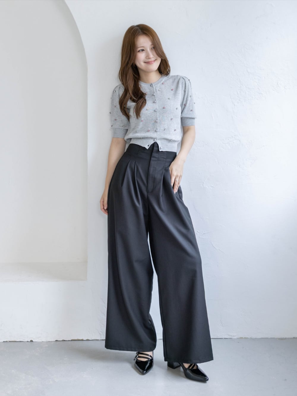 ブラック系のパンプス、ブラック系のスラックス、グレー系のカーディガン/ボレロを着用したレディースの春コーディネートの2枚目の写真