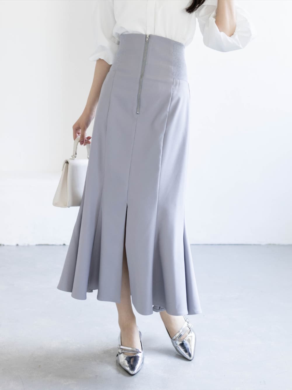 シルバー系のパンプス、ホワイト系のシャツ/ブラウス、グレー系のスカートを着用したレディースの夏コーディネートの6枚目の写真
