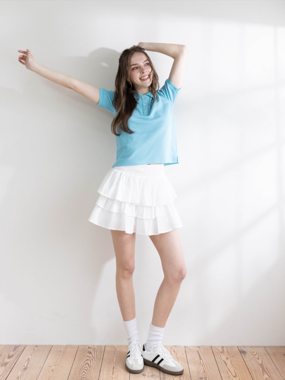 ホワイト系のその他パンツ、ホワイト系のスニーカー、ブルー系のポロシャツを着用したレディースの夏コーディネートの2枚目の写真