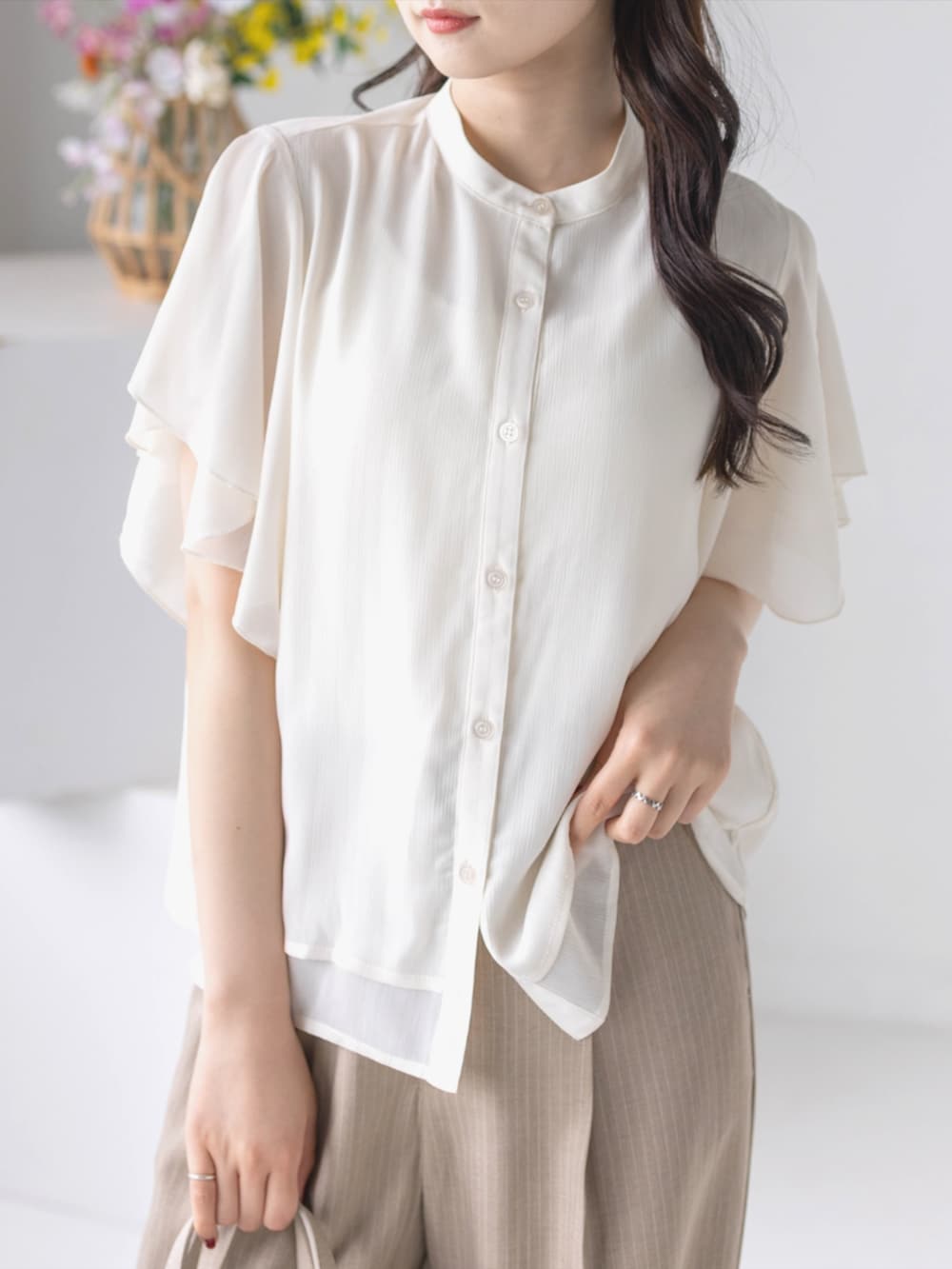 ベージュ系のスラックス、ホワイト系のパンプス、ホワイト系のシャツ/ブラウスを着用したレディースの夏コーディネートの7枚目の写真