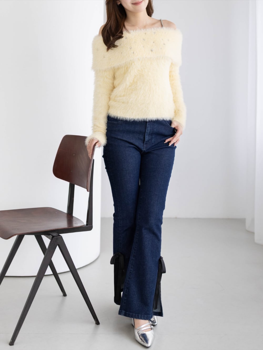 シルバー系のパンプス、ブルー系のデニムパンツ、イエロー系のニット/セーターを着用したレディースの秋コーディネートの5枚目の写真